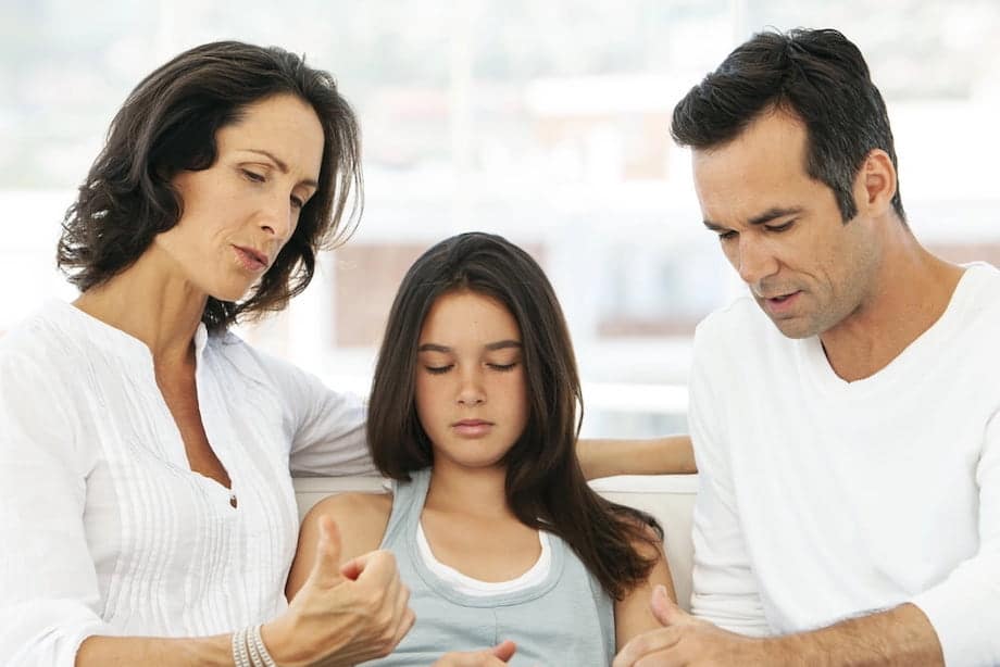 Parents having discussion with teenage girl at home